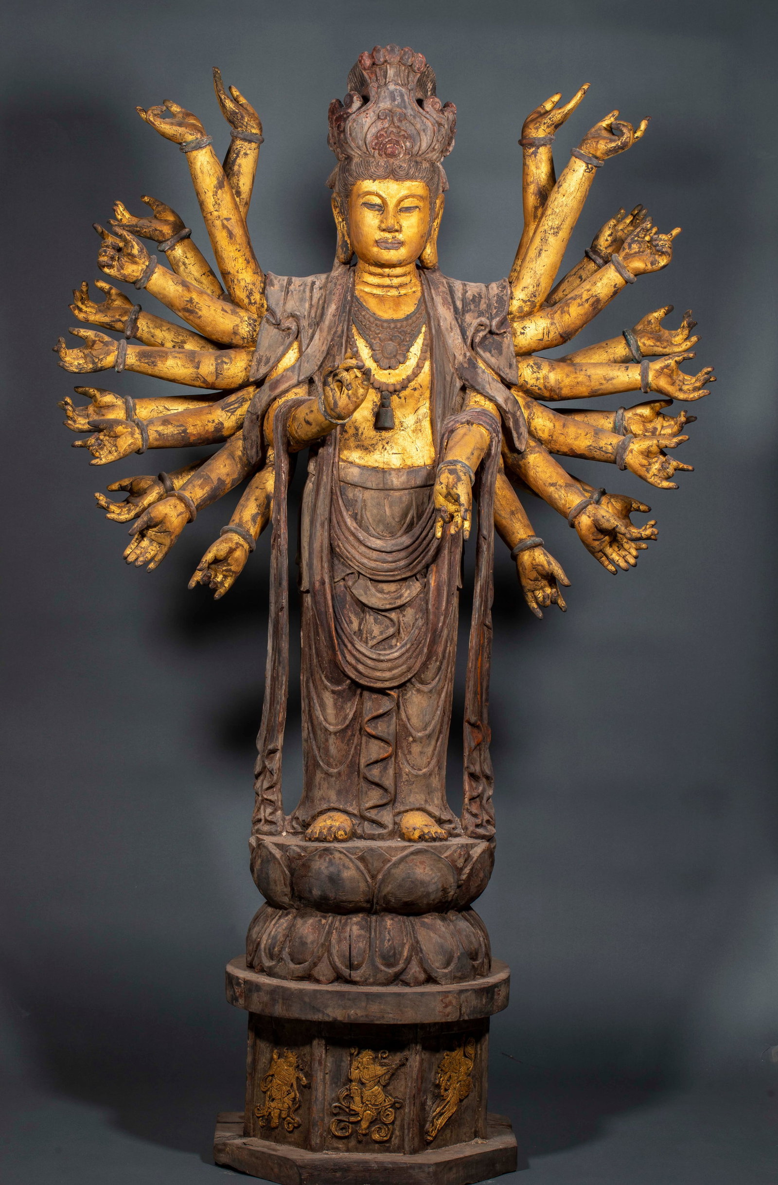 Baimu Qianshou Guanyin: Woodcarving statue, Bodhisattva stands on the base of a double-layer lotus platform, with multiple arms extending all over, each palm with different handprints, body and arms gilded, clothing with ori