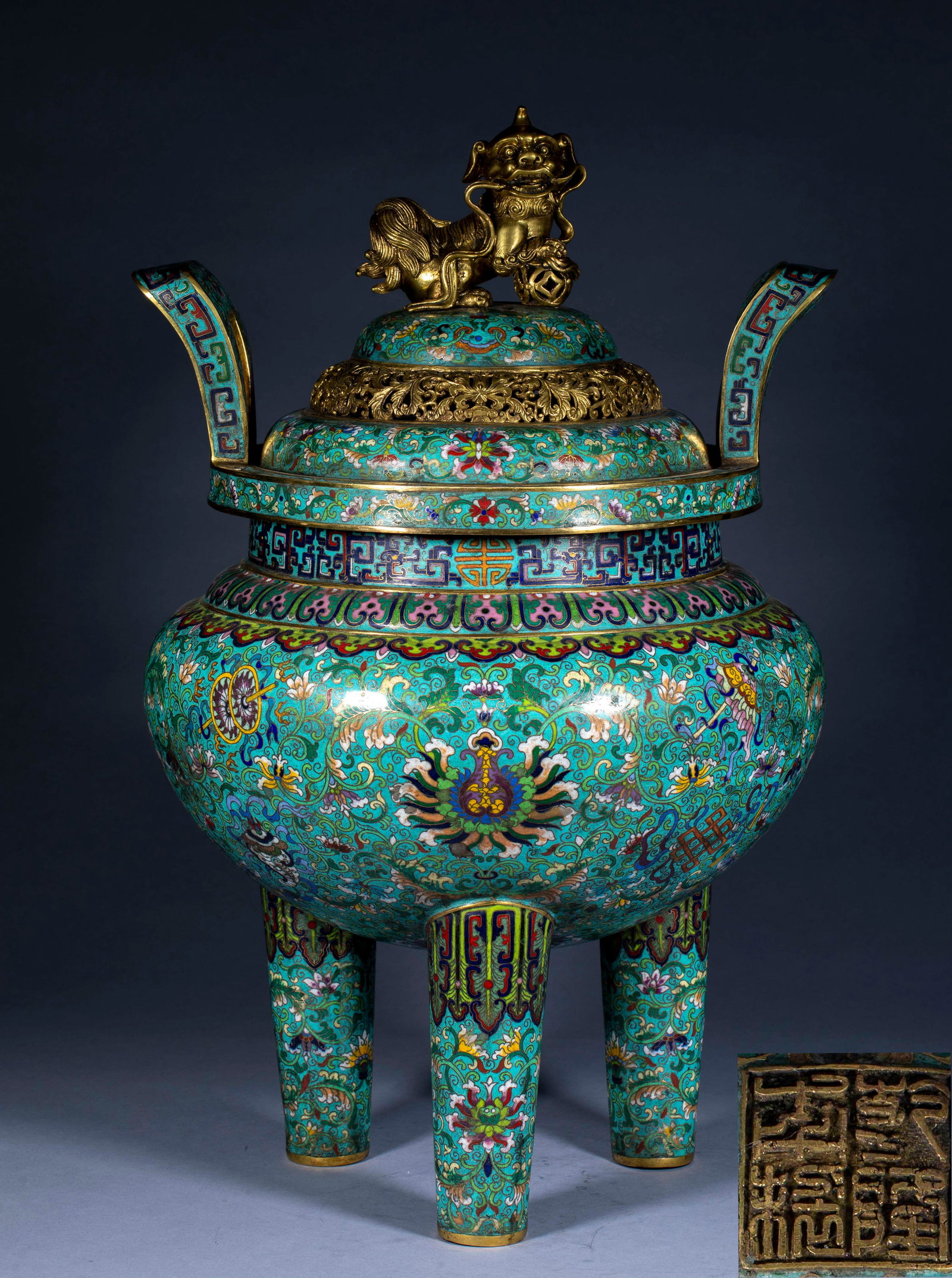 Qianlong Annual Cloisonneenamel Shiding Flower Pattern Aromatherapy Furnace: Copper gilded, tripod-shaped, with a lid. The top of the furnace cover is gilded with a lion playing with a ball button, and the cover surface is hollowed out with a twig-bound pattern. The two sides