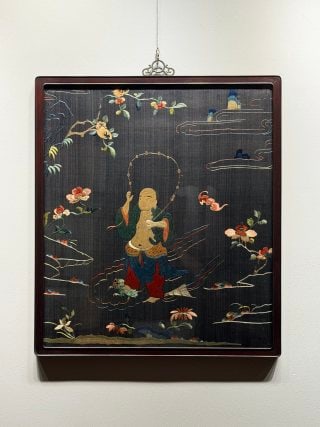 Jin Chan, a Liu Hai Opera with Su Embroidery in Qing Dynasty: Wooden frame mounting, reeling technology, the background color is black. The main body of the picture is Liu Hai sitting on the water, with a golden toad on his foot and a string of copper coins in