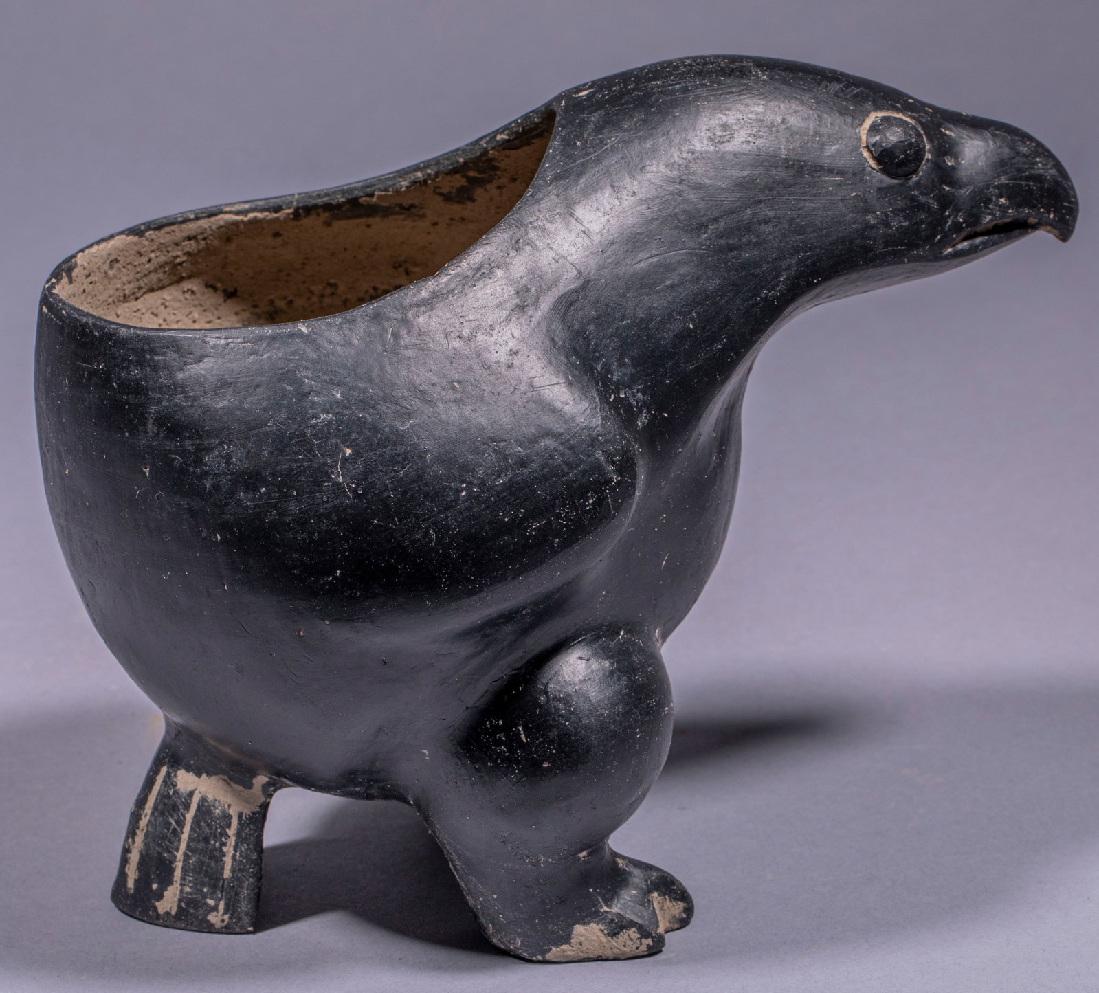 Eagle pottery: As a whole, it is shaped like a bird of prey, with the bird's head extending forward, a pointed beak, round eyes and white space decoration on the eyes. An opening is opened on the bird's back to