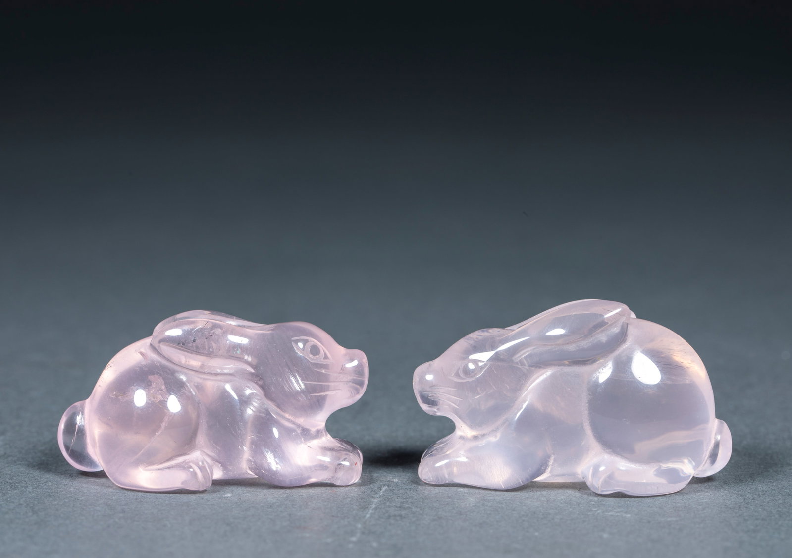 A pair of crystal rabbit-shaped ornaments: Two pink-crystal lying rabbits, the crystals are light pink, the texture is transparent, and the natural cotton wool texture can be seen inside. The rabbit is in a prostrate posture, with its ears