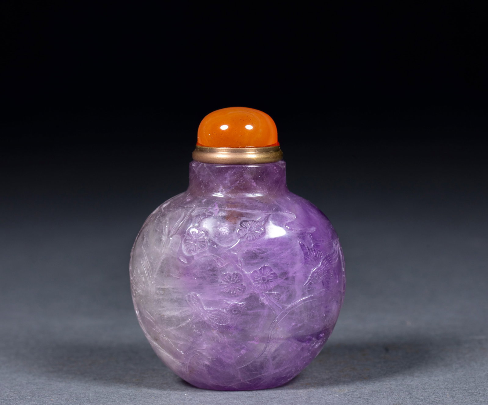 Amethyst flower snuff bottle: Amethyst texture, the crystal is purple with alternating shades, and natural crystal grains can be seen inside. The pot body is embossed with flower-and-bird patterns, carved with plum branches and te