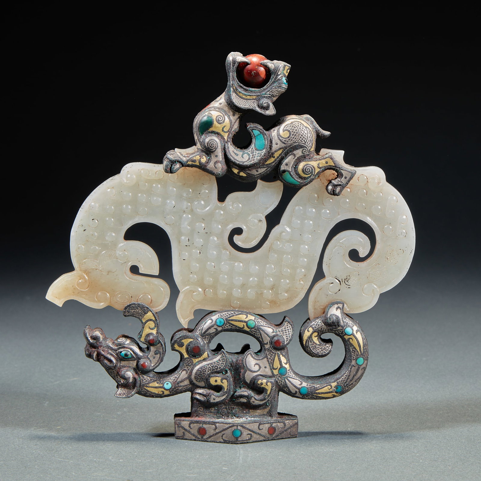 Bronze, gold and silver inlaid with turquoise, agate and jade dragon-shaped ornament "Three Dragons": The main body is a white jade carved S-shaped dragon, and the jade dragon is matched with staggered gold, silver and bronze components. The components are carved with precious stones such as turquoise
