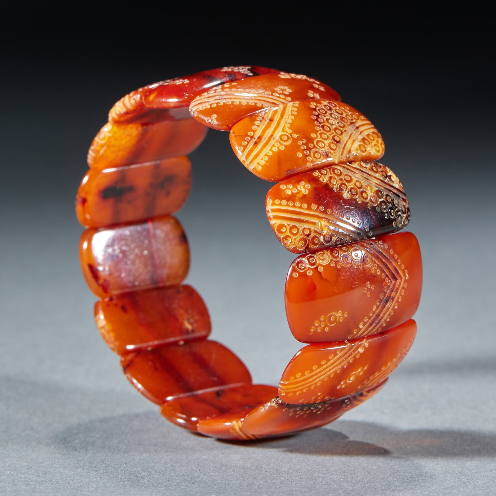 Beeswax bracelet: A wrist row is formed by connecting a plurality of curved cards with beeswax in series. The beeswax is red and orange, and the cards are engraved with geometric patterns of circles and lines, and the