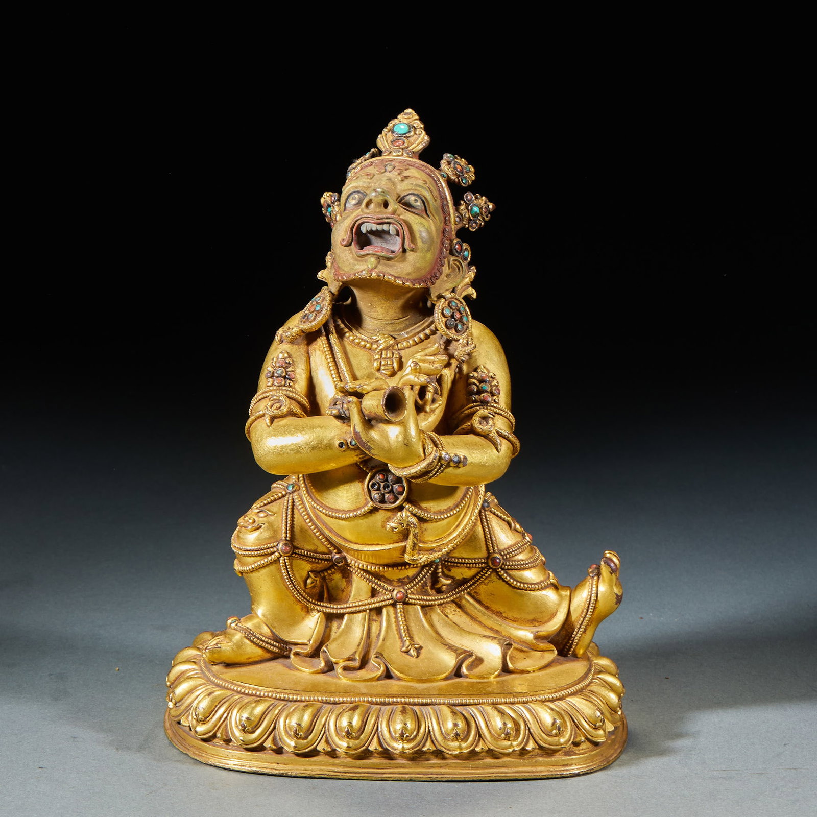 Bronze and gold can eat the empty Buddha.: The statue is made of bronze and gold, and the game sits on the base of lotus petals. His face glowed and his mouth opened, he wore a crown, turquoise and red ornaments all over his body, and he wore