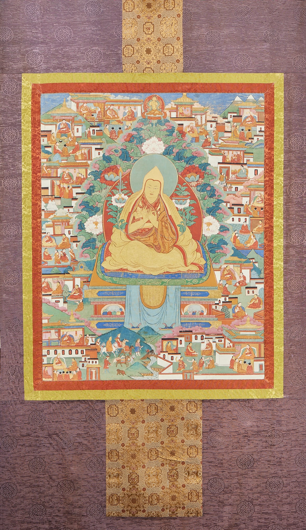 Master Zong Kaba Thangka: Lord Thangka is revered as Zong Kaba, sitting on the lotus platform with his hands tied and his mouth sealed, and the lotus flowers are placed beside him. There are many groups of architectural scenes