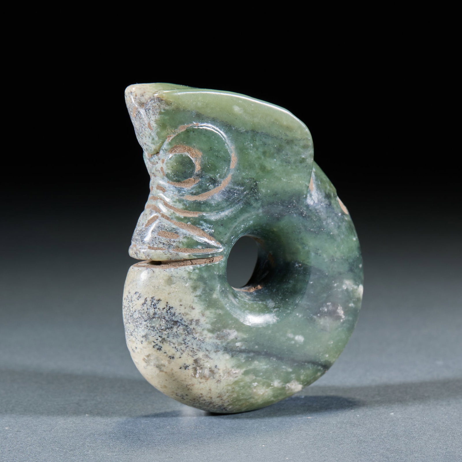 Red Mountain Culture Yuzhulong before Ming Dynasty: Sapphire texture, with gray-white and black-brown spots locally. The whole body is curled in a C-shape, the head is carved with round eyes and a convex kiss, the face is carved with a negative line pa