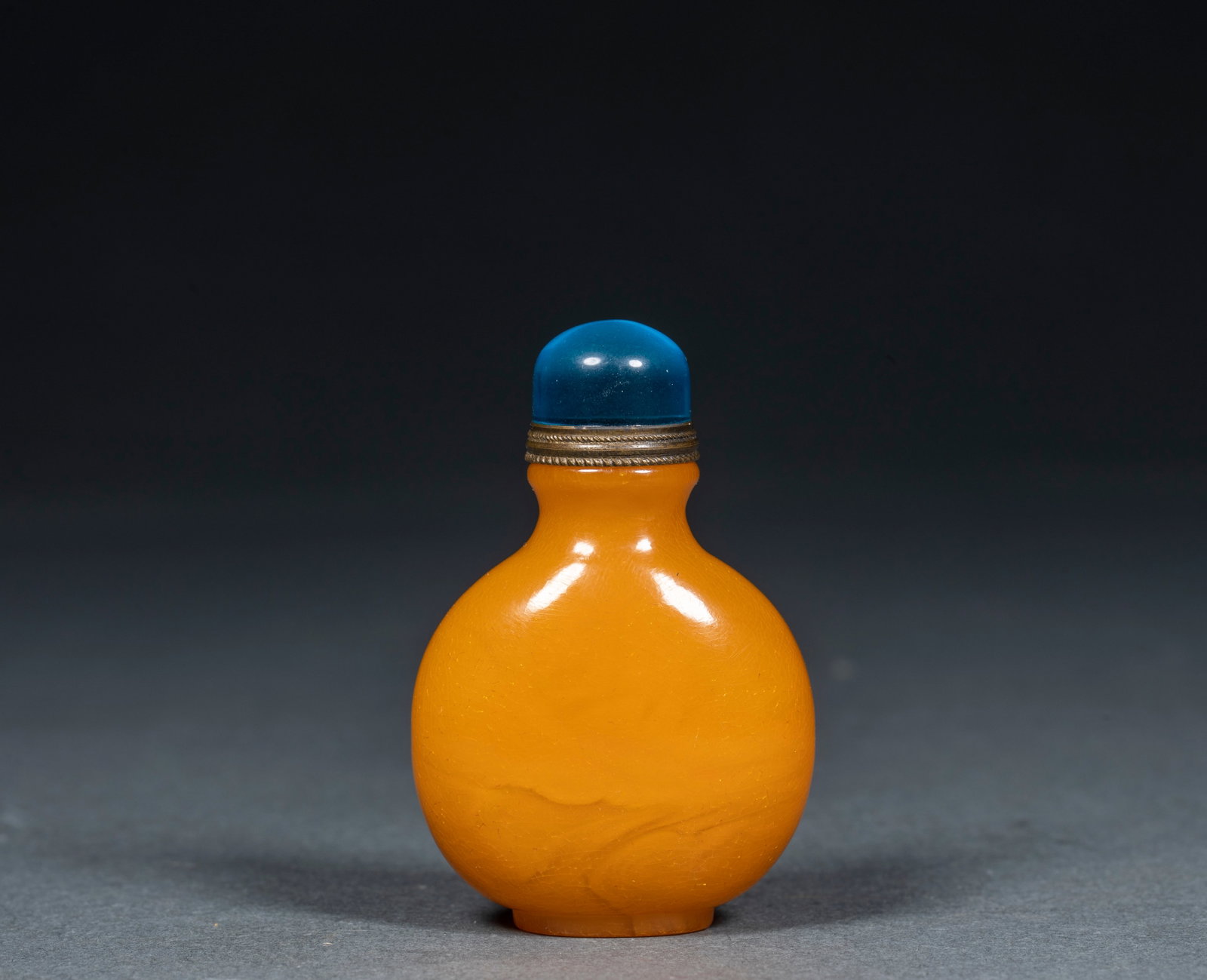 Beeswax snuff bottle 2: The texture of the feeder is even and bright yellow, and the natural flowing texture can be seen on the bottle body. The shape of the device is a standard flat round snuff bottle, with a shoulder, a c