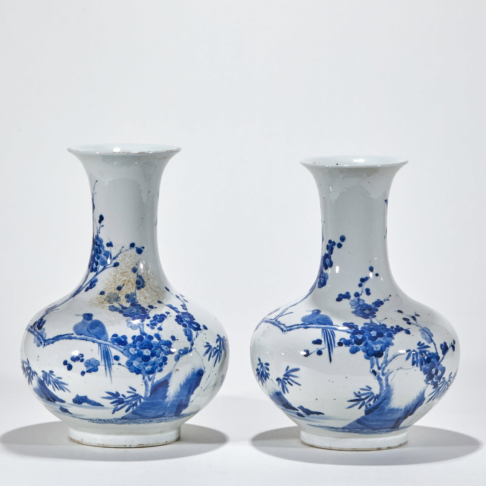 A pair of blue and white flowers beaming and admiring bottles.: Porcelain, in pairs Lip curl, long neck, bulging belly, circle foot. The whole body is blue and white, and the bottle is painted with flower-and-bird ornamentation, plum blossom branches are painted