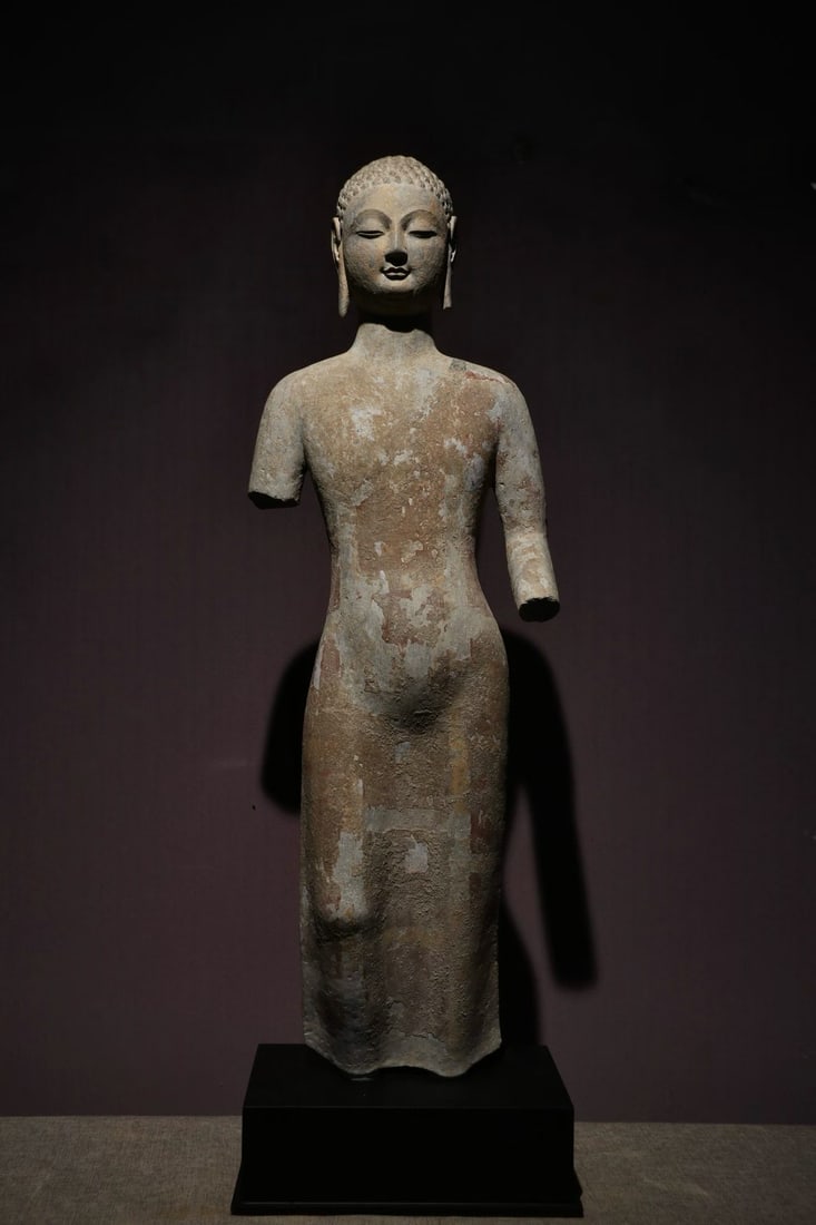 Qingzhou Buddha statue: The stone round carving of Sakyamuni stands as a Buddha, with a high bun, a round face, slightly closed eyes and a calm expression. Wearing a shoulder-length thin coat, the clothing pattern is simple