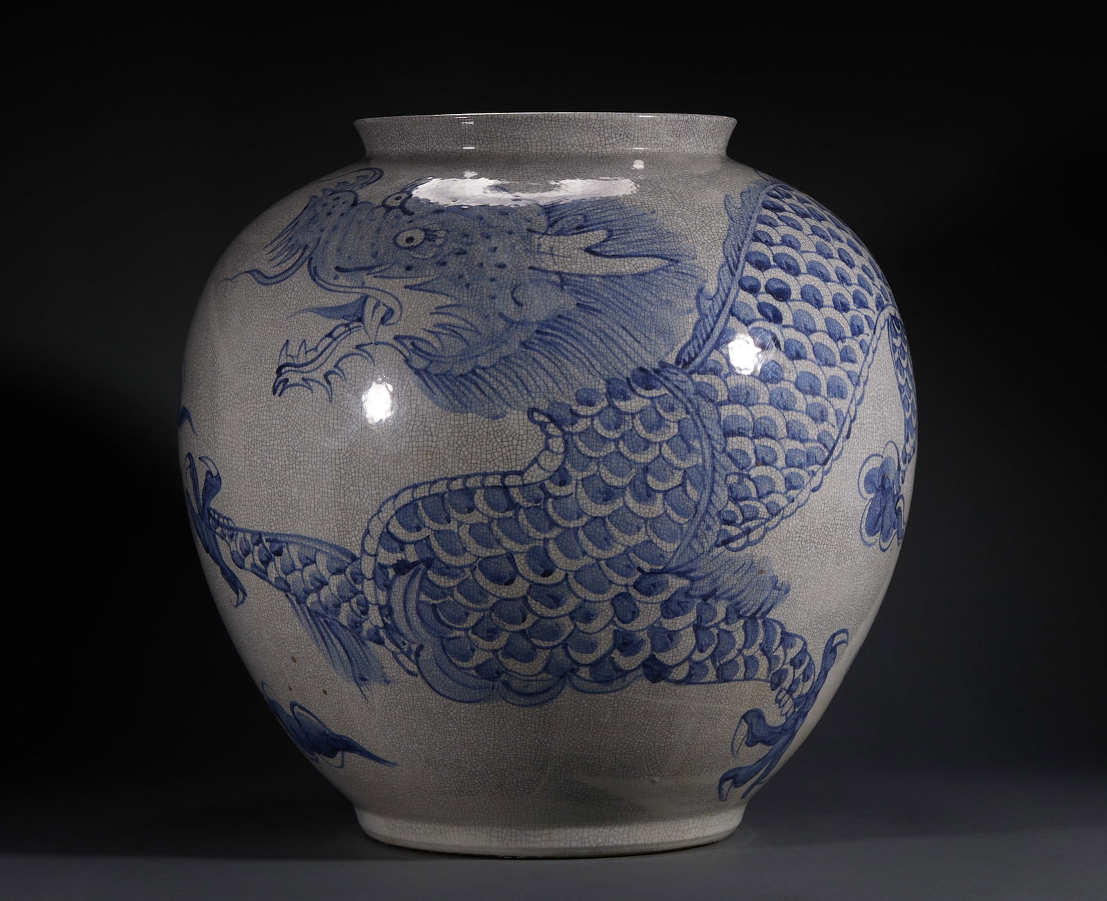 Korean White Porcelain Dragon Moon Pot: The glazed surface of the big pot is covered with open pieces, and the pot body is painted with blue and white dragons, with fine scales, flying manes and vigorous limbs, supplemented by auxiliary flo