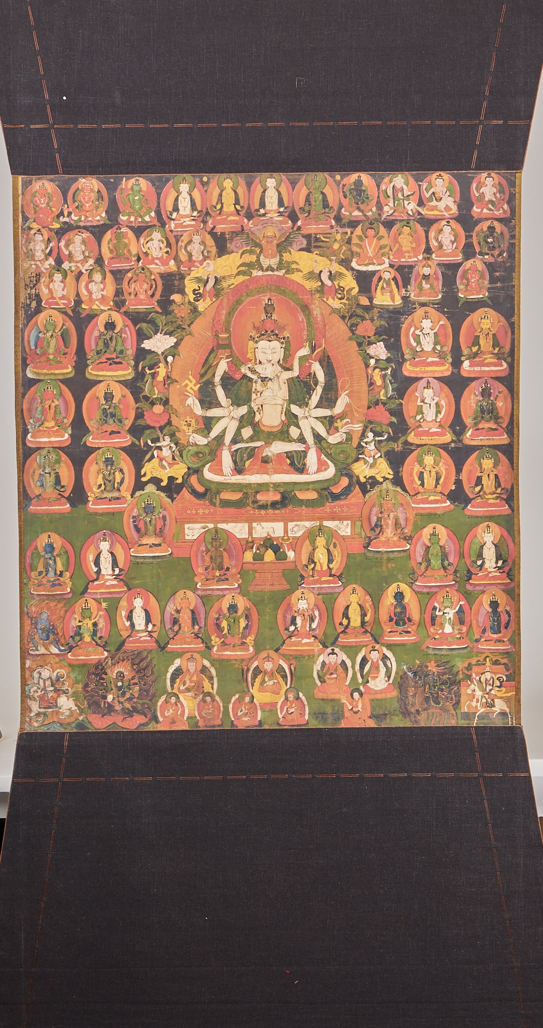 Zunsheng Buddha Mother Thangka: Thangka canvas has a dark background, and the main statue is in the middle of the picture. It is a multi-armed double-body deity with a crown on his head and a white body. Each arm holds an instrument
