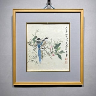 Zhang Daqian's double happiness picture: Lined with gray-blue cardboard. The heart of the painting is square, and the paper is colored. It depicts two blue-tailed birds perched on a flower branch with bamboo leaves and flower buds on it. On
