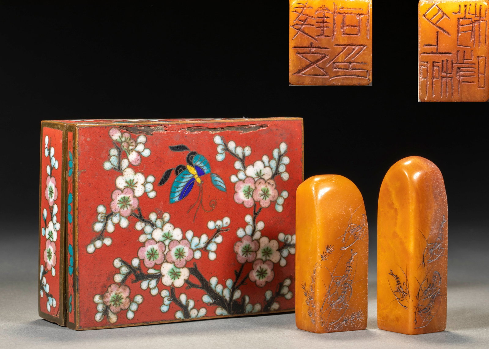 Qibaishitian Huangshi Qunxia Seal Group 1: Rectangular cloisonne enamel box, the box body is red, the cloisonne is filled with color to draw plum branches and vines, and a blue butterfly is drawn on the box surface. Two yellow stone seals are 