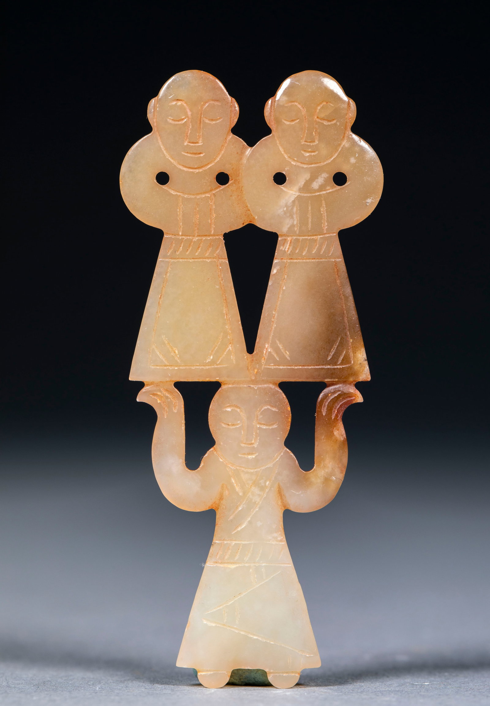 Sanyuren: Topaz texture, with brown spots locally. As a whole, it is a three-person figure, with a jade figurine below holding his arms high and his hands holding up two jade figures standing side by side