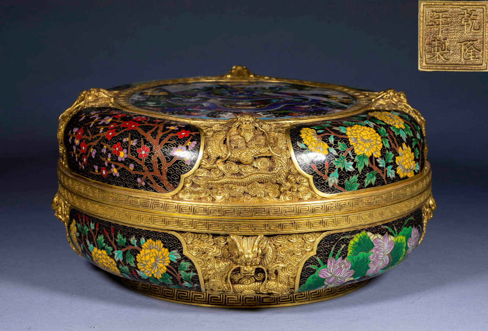 Qianlong year Cloisonneenamel dragon cover box: Copper tire, round cover box. The box body is gilded in a large area, and the four seasons flowers such as plum, chrysanthemum and lotus are painted in the box body and the box cover, respectively,