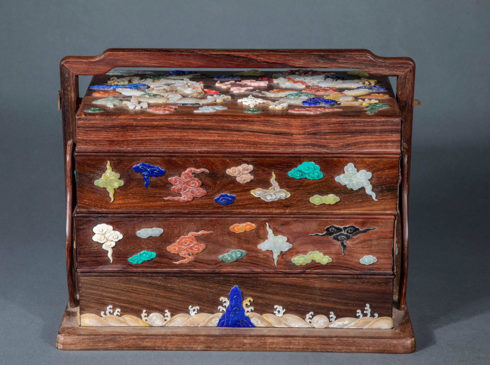 Qing rosewood inlaid with multi-treasure inlaid with dragon treasure box: The main body is Huanghua pear hardwood, with arched girder and layered multi-cell structure. The surface of the box cover and the box body are inlaid with various kinds of precious stones such as tur