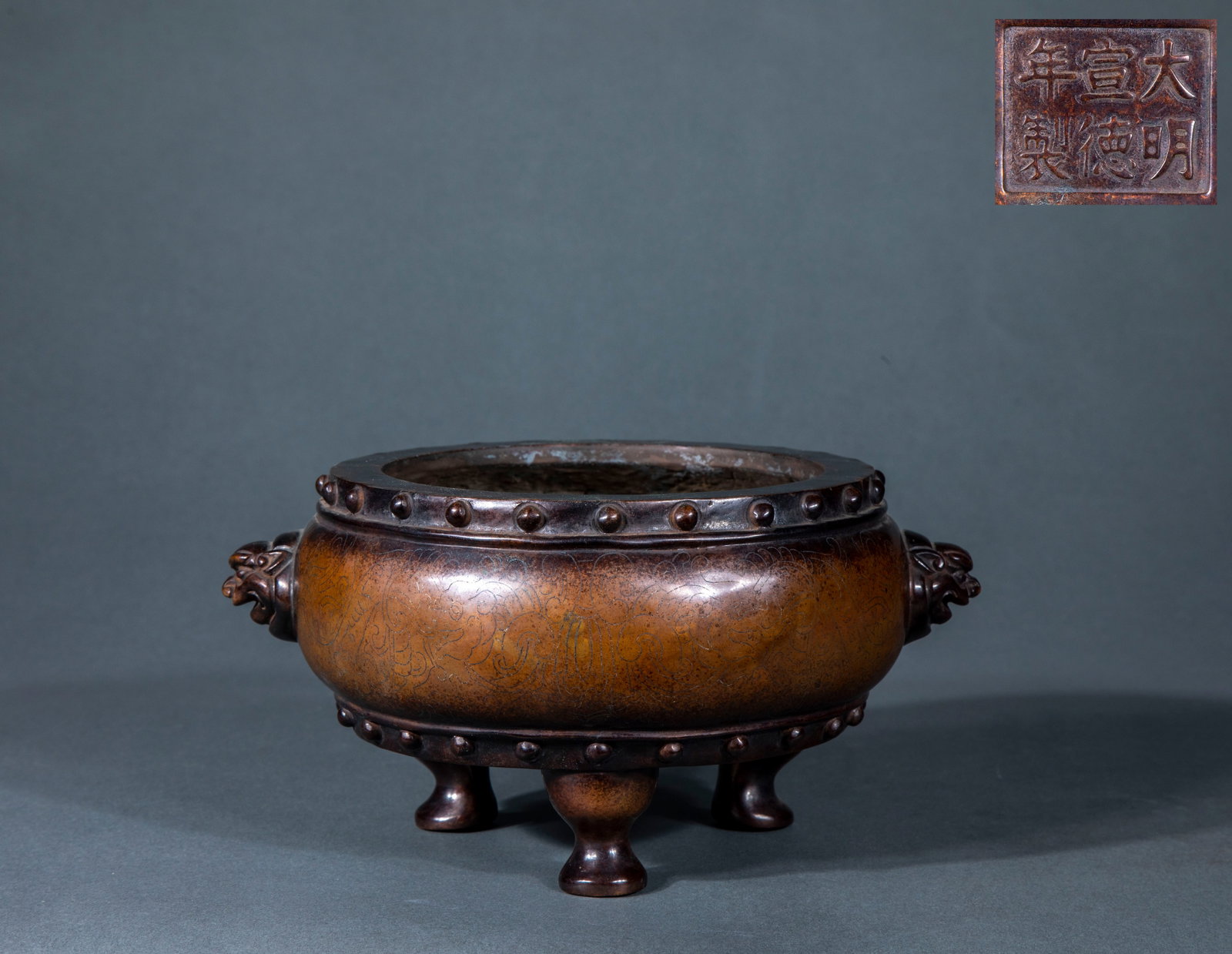 Ming Xuande double animal ear incense burner with dark carved dragon pattern: Copper incense burner, the furnace body is flat and bulging. Drum nail patterns are arranged along the mouth and the lower circle of the abdomen, with animal heads and ears on both sides and three