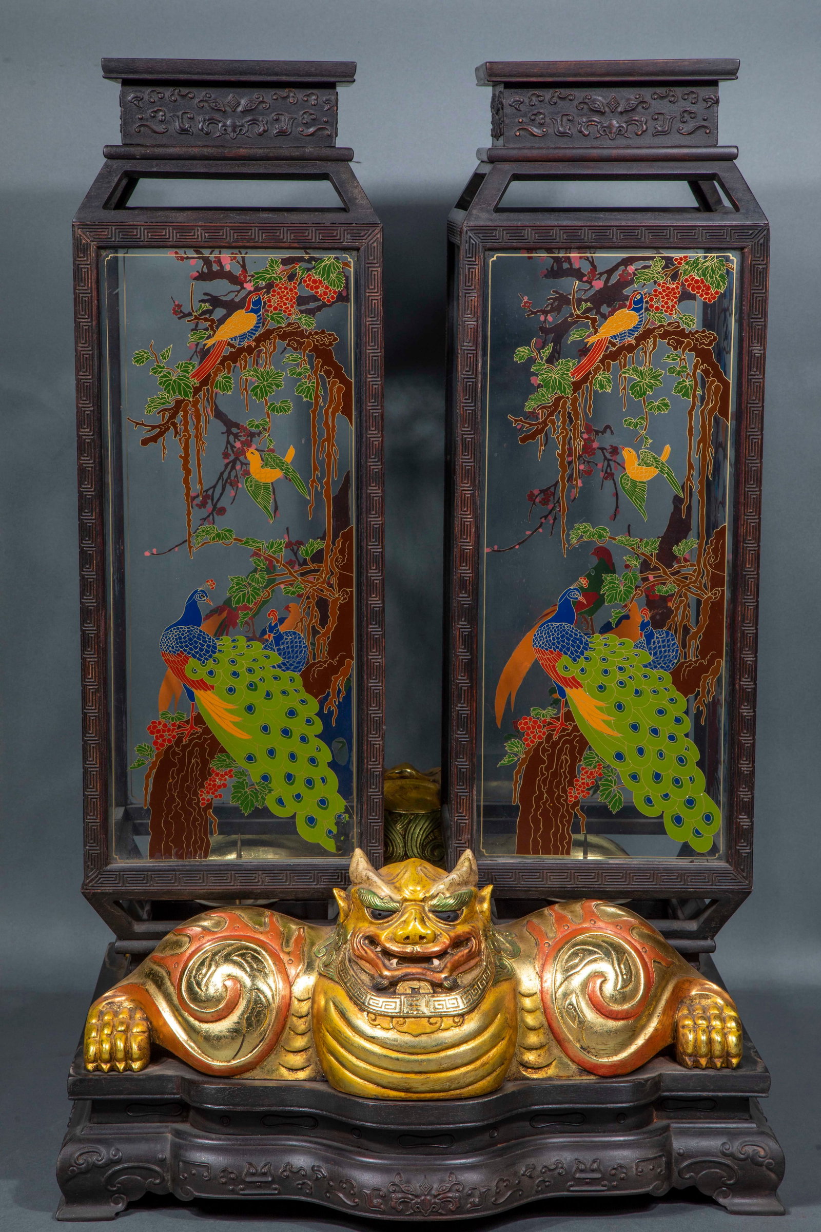 A pair of painted palace lanterns painted by lying animals covered with red sandalwood and gold.: Pairs of vertical palace lanterns, the frame is made of rosewood, and the edges of the frame are carved with back lines and branches. Glass is inlaid on all sides, and peacock, ribbon bird and plum