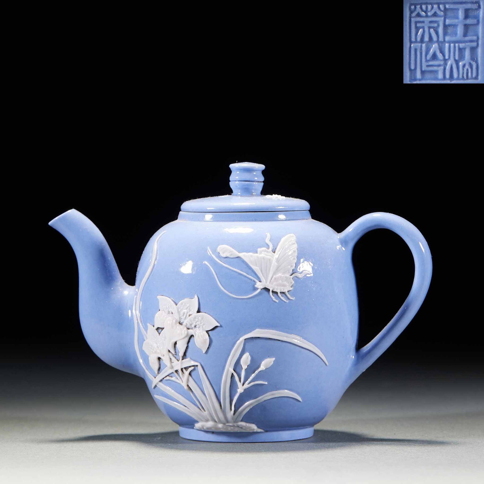 Wang Bingrong blue glaze piercing butterfly holding a pot: The pot is covered with azure glaze. The pot is drum-shaped, DC-rising, ring-shaped handle and lid with orb button. The outer wall of the pot is decorated with white porcelain, including orchids and