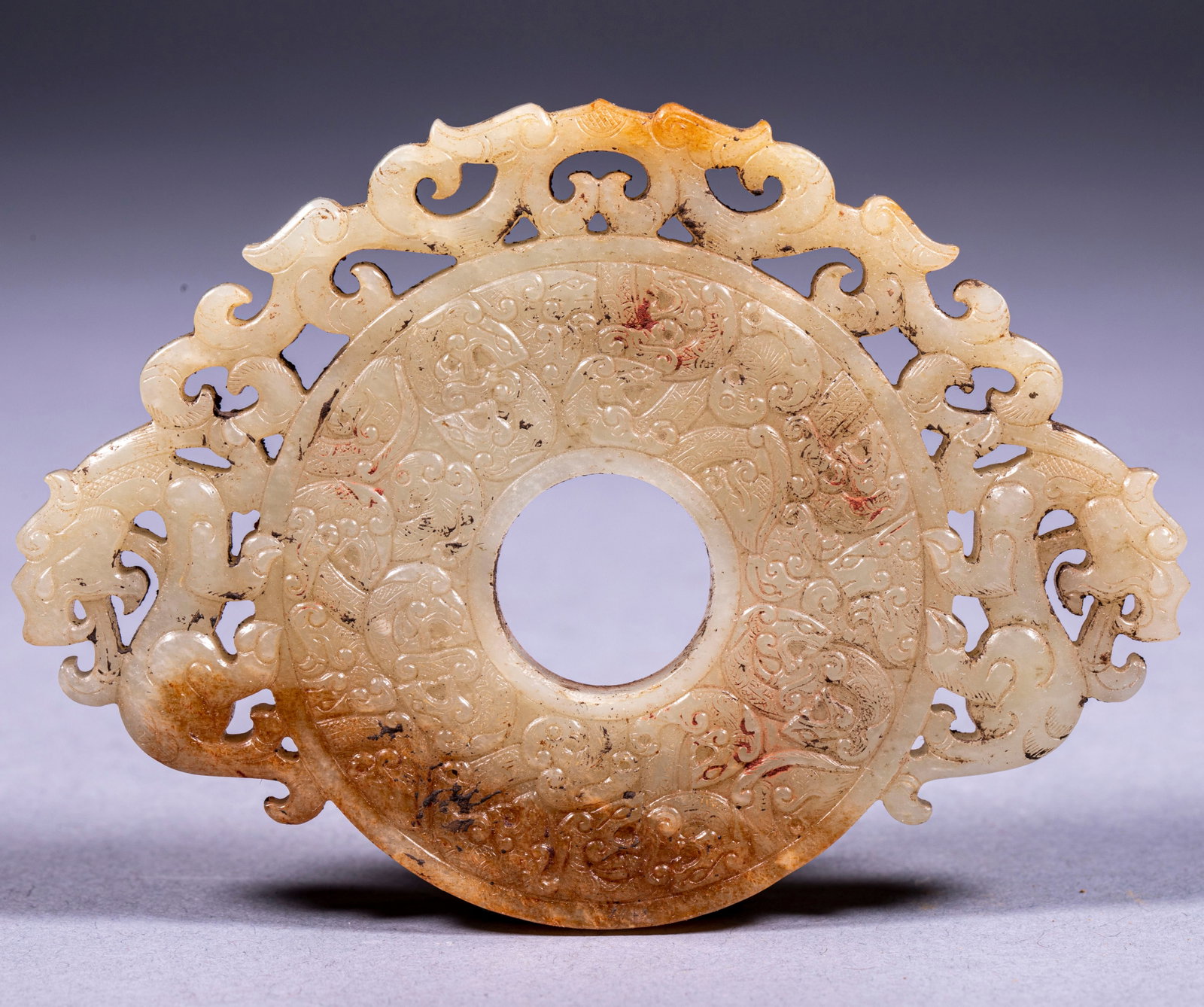 Carve out the jade wall of tiger by hollowing out: Jade is bluish-white, partially yellow-brown. The container is a standard round wall with a round hole in the center. The wall is full of complicated patterns of rolling grass and beasts, with fine ne