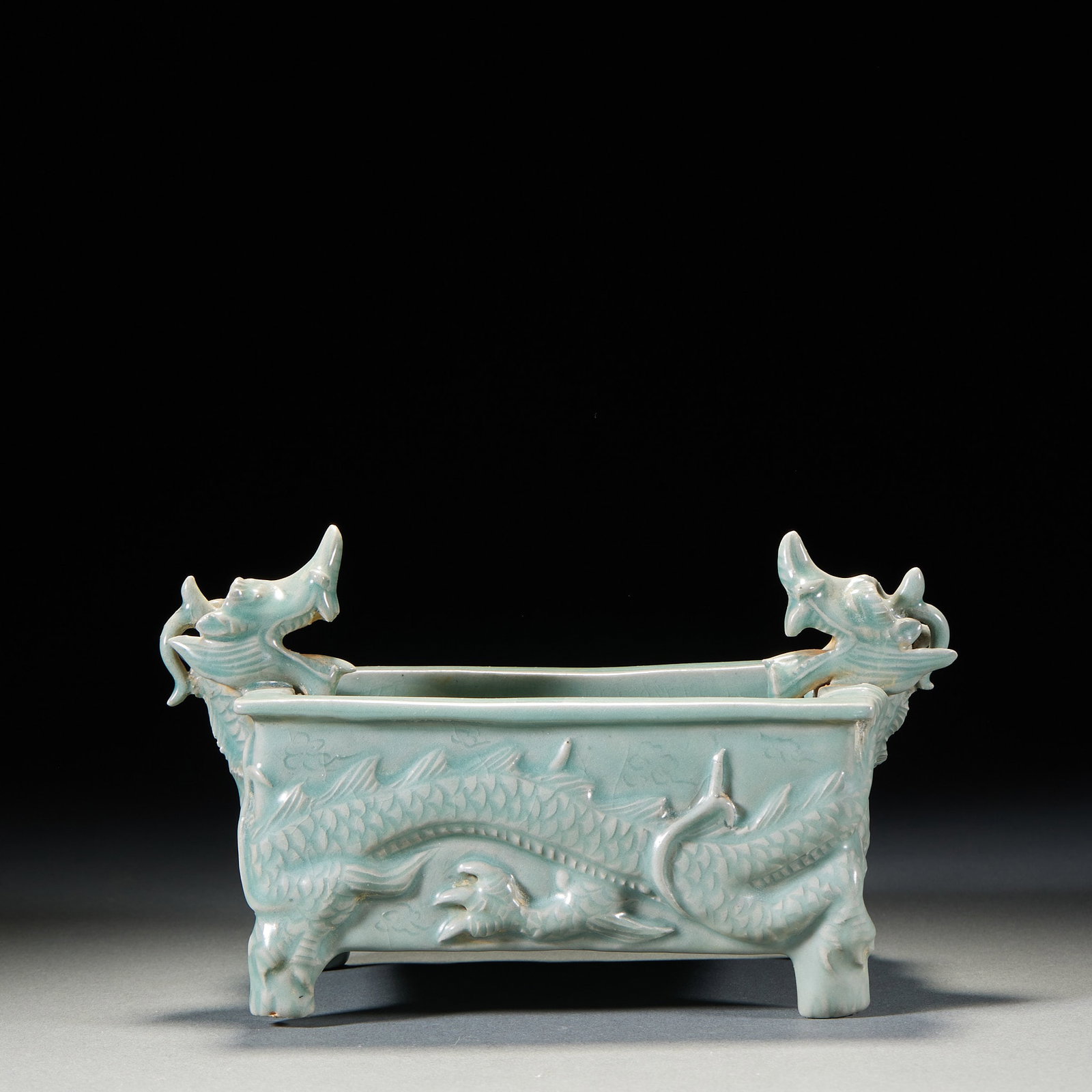 Celadon double dragon pattern four-legged square tripod: Blue glaze porcelain, the overall shape is rectangular square furnace. The high relief on the outer wall of the furnace body is a complete dragon, and Long Lin and African claws are clearly depicted.
