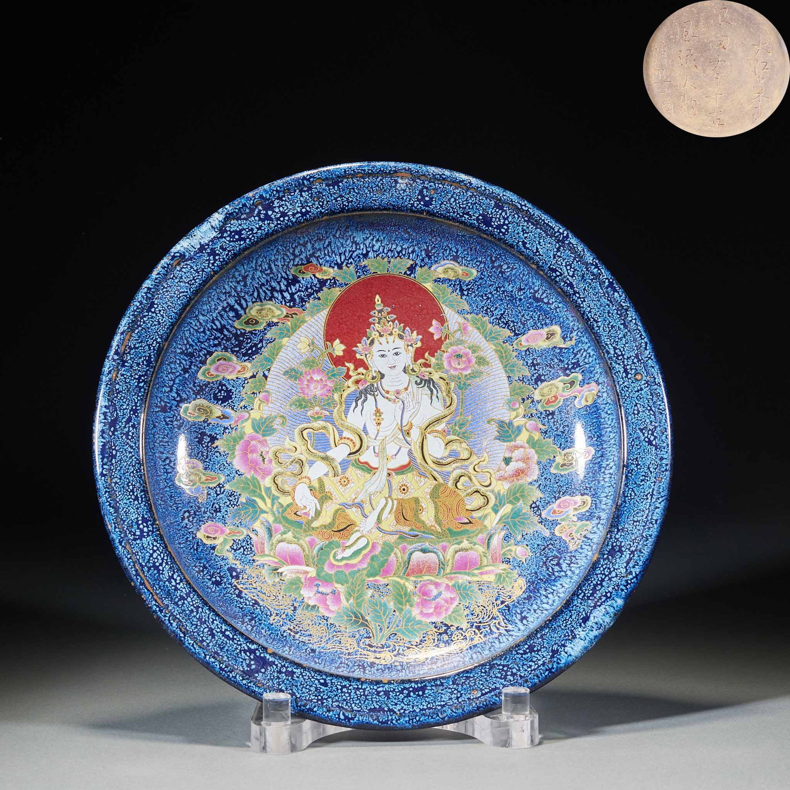 Blue glazed Tara is like a plate: Round folded edge plate, the edge of which is kiln glaze with blue background and dense white spots. The center of the plate is painted with a statue of Tara, who sits in the lotus seat, surrounded