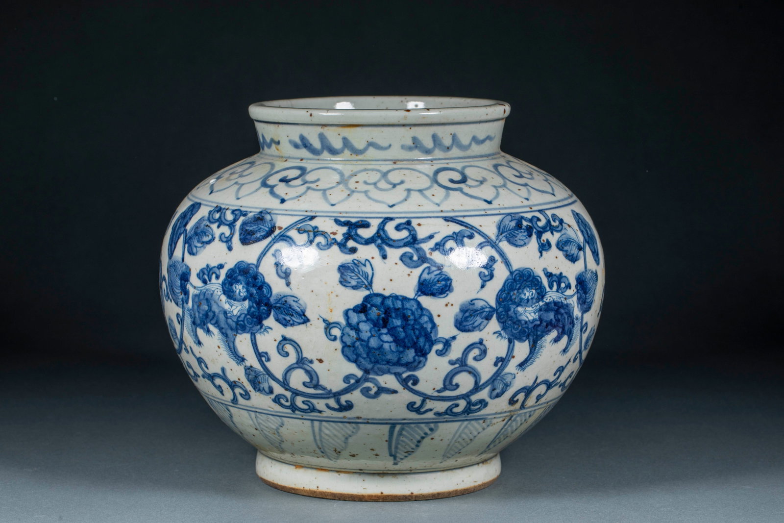 Blue and white lion flower pattern jar: Round mouth, short neck, rich shoulders, bulging abdomen and full feet. The white glaze of the body is blue and covered with tiny brown iron black spots. The mouth edge is painted with sea water patte