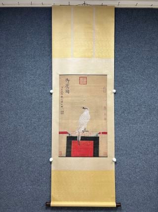 Silk copy of Song Huizong Imperial Eagle Map: As a whole, it is mounted on a Chinese vertical shaft, and the ceiling and the ground are made of beige silk, with the center of the painting. Draw a white eagle in the painting heart, standing on