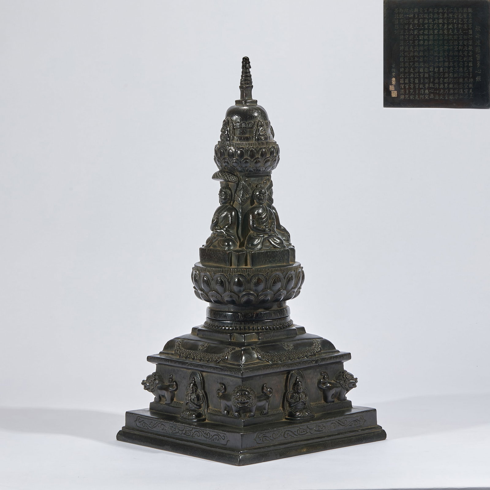 Thymelaeaceae stupa with carved heart sutra.: The whole device is black stone with a square base, and the side wall of the base is carved with lions and sitting buddhas; The tower is divided into layers, each layer is carved with lotus petals