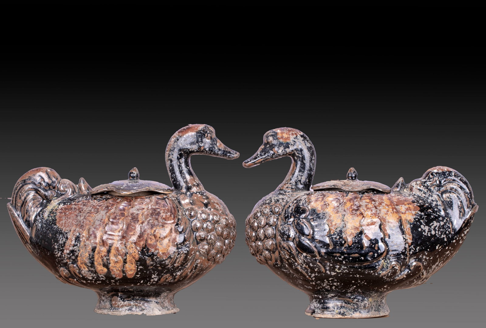 A pair of goose-shaped jars with sauce glaze: The whole device is molded into a duck shape and preserved in pairs. The duck is plump with its head held high and its neck bent, with an opening in the back, and a follower cover with an orb button