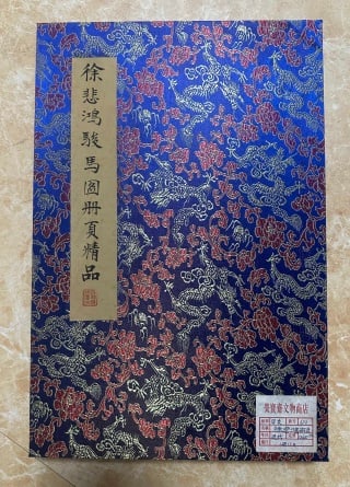 Xu Beihong's steed figure 12 opens: The cover of the album is made of blue brocade, and the brocade surface is woven with gold and silver thread dragon patterns and flower patterns. The cover is labeled with beige vertical bars, and