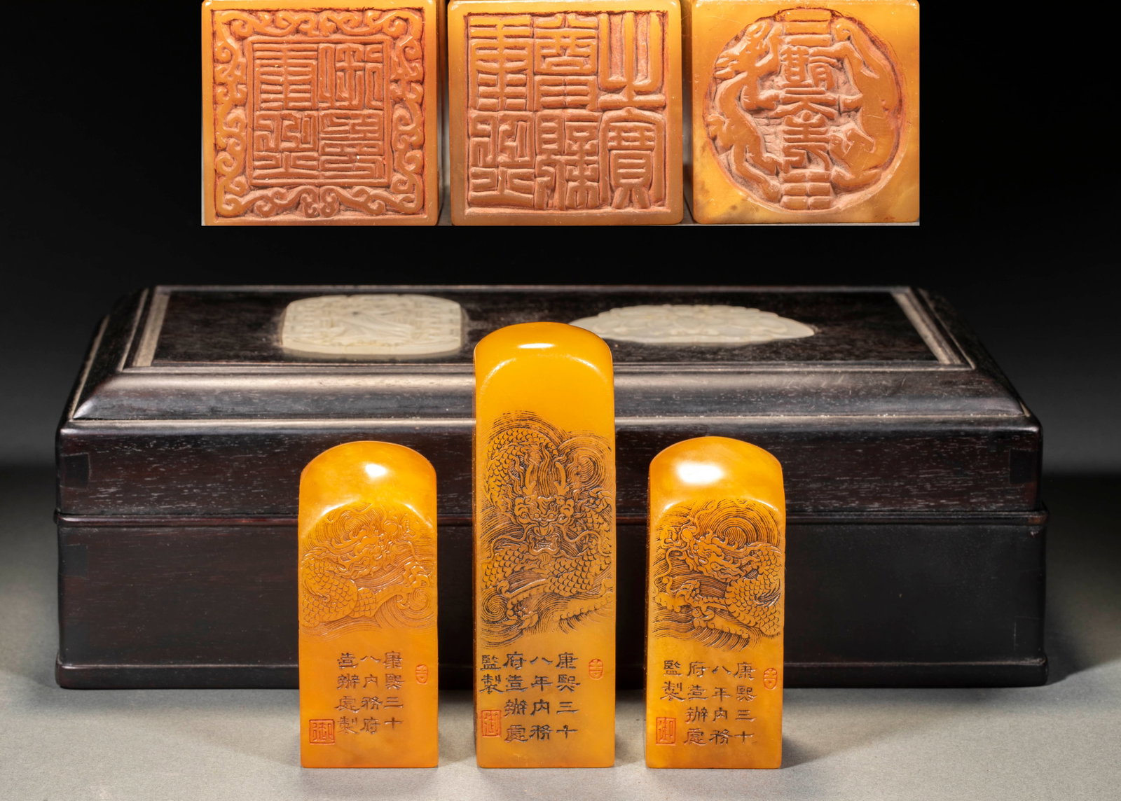 Kangxi Niantian Huangshi Dragon Seal Group 1: Three-way yellow stone seal with dark wooden storage box with white jade inlay. The seals of the three parties are all in the shape of straight buttons and square columns, and the seal body is
