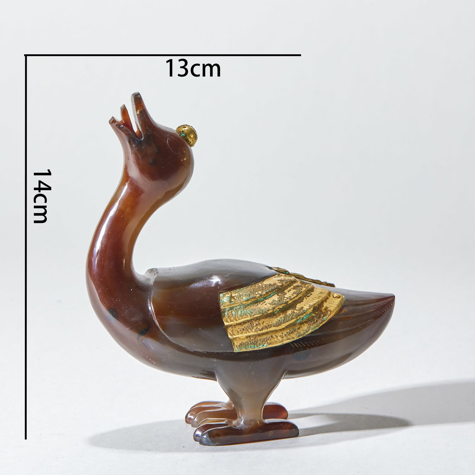 Agate duck-shaped ornaments before Ming Dynasty: The background color of agate is dark brown, the duck's beak is open, the top of the duck's head is inlaid with gold ornaments, and the wings are inlaid with gold-plated wing ornaments. The duck's