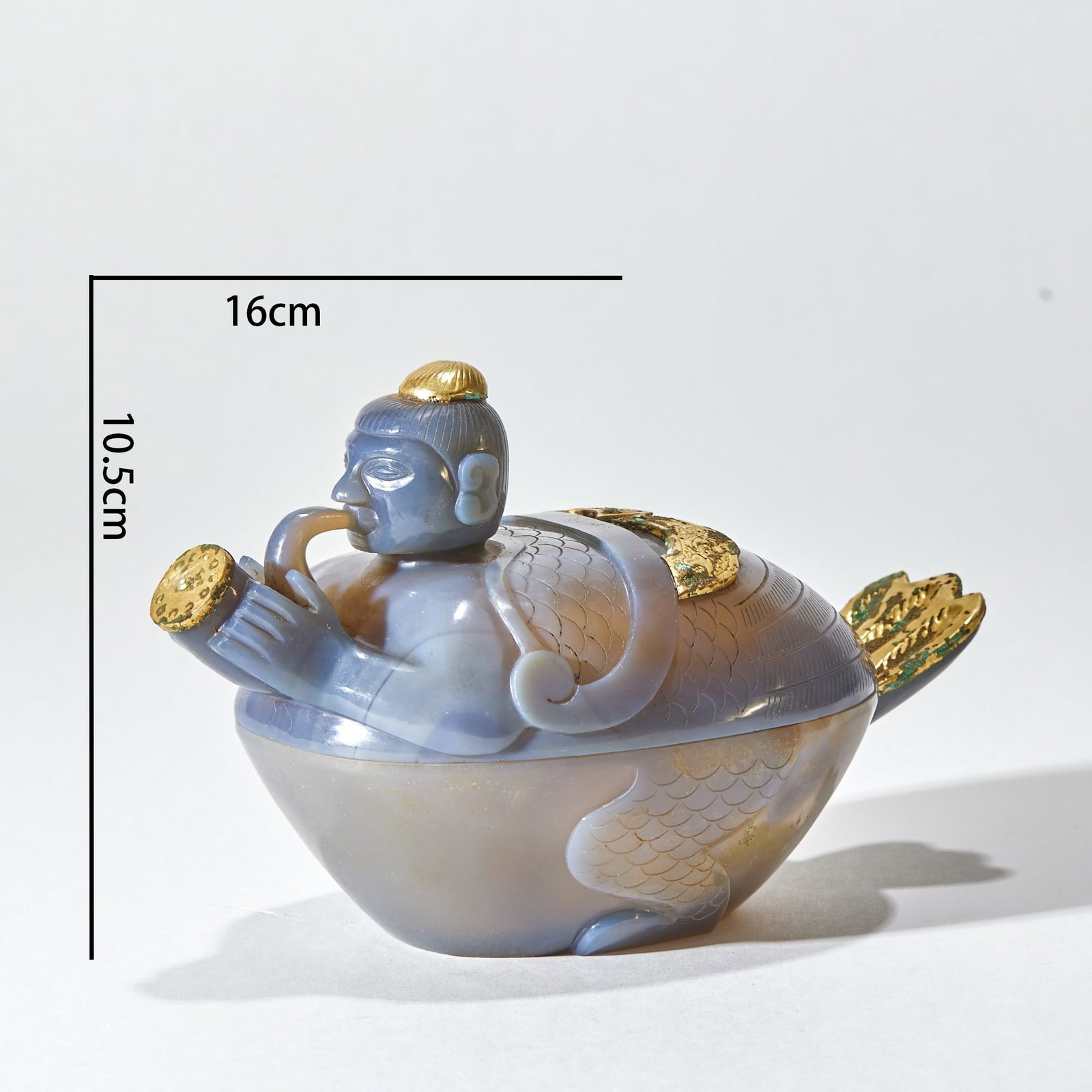 Before the Ming Dynasty, the boy goose covered the box.: As a split cover box, the container is shaped as a whole in the shape of Garuda. The figure has a bun, a gold hat on the top of his head, a human face, scaly wings, a tubular spout in his mouth and a