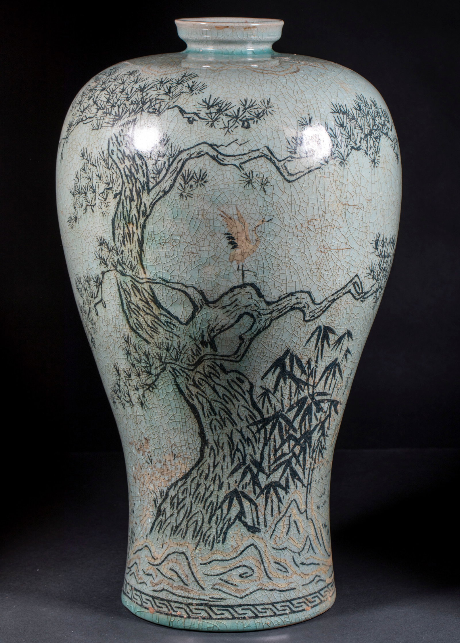 Koryo celadon pine crane flying plum bottle: Plum vase type, light blue glaze, full of open pieces. Gu Song, cranes, bamboos, rocks and pine branches are painted in ink on the bottle body. The crane stands on the pine trunk, and the bottom edge