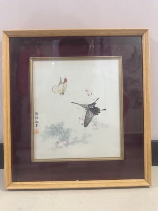 Jingshu Pan Butterfly Picture Frame: The outer frame is a light-colored wooden frame, the inner layer is equipped with a crimson substrate, and the narrow edge of the metal is clamped to fix the painting center. The picture shows two