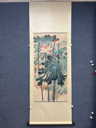 Zhang Daqian makes money with kindness.: The paper is colored with vertical shaft, and the whole picture is mounted in traditional Chinese style, with beige silk and wooden shaft head. The main body of the picture is the scenery of the