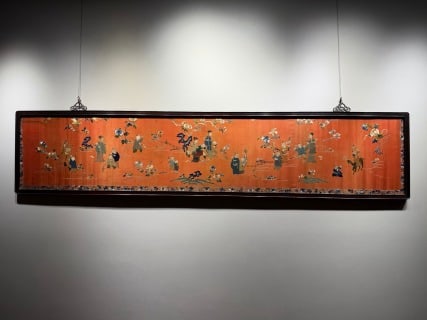 Suzhou embroidery baby play in Qing dynasty: The orange-red ground silk is hung horizontally with a dark wooden frame. Many groups of ancient figures, including literati, children and horseback riding figures, are woven by the silk reeling