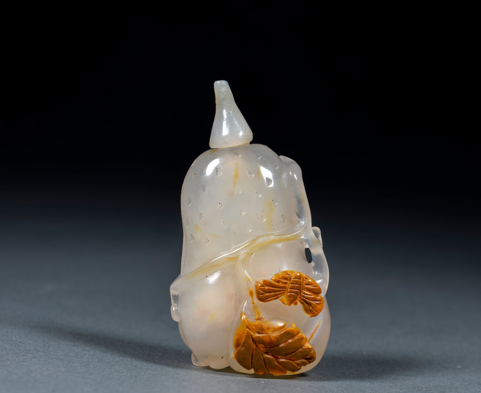 Agate bergamot snuff bottle: The whole device is carved with agate, the main texture is transparent and white, and the natural yellow-brown skin color of agate is used for pretty carving. The body of the vessel is shaped like a