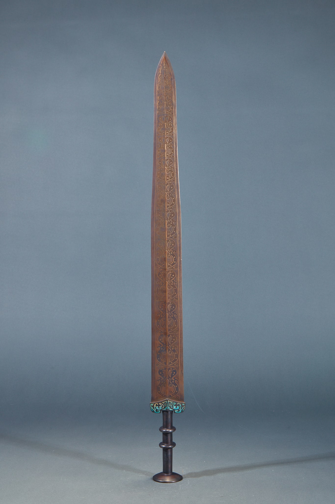Wrong gold and silver sword: Bronze sword, slender body, full of gold, covered with continuous curly patterns; The sword lattice is inlaid with turquoise, the hilt is multi-hoop-shaped, and the head of the disc sword is complete
