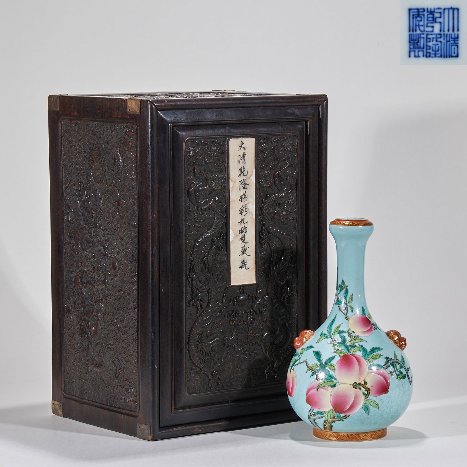 Qing Qianlong's annual famille rose nine peach ear bottle: Porcelain bottle, garlic mouth, long neck, round belly and full circle. The ground of the bottle is light blue, and the bottle is painted with pastel and nine peach patterns. The peaches are full and 