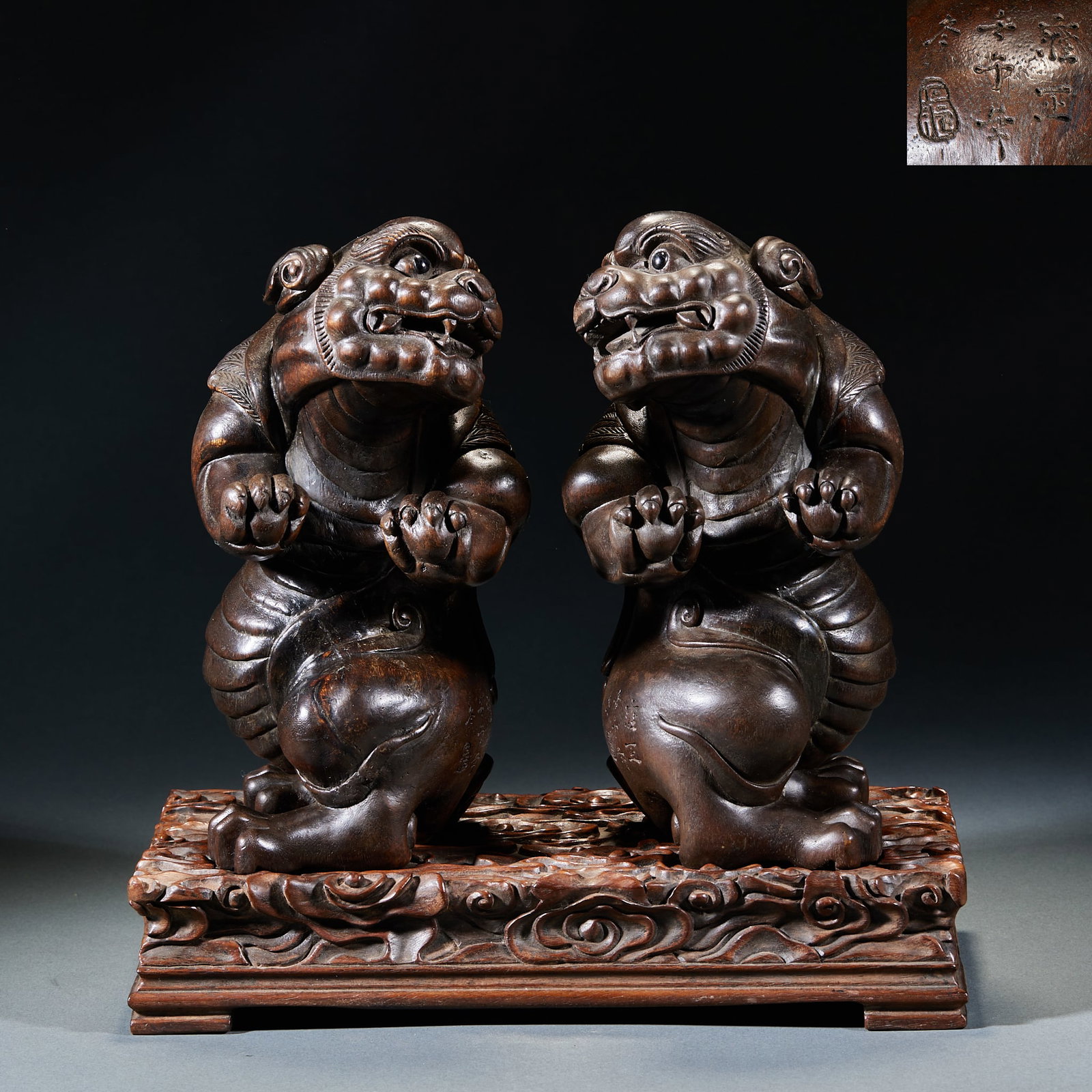A pair of agarwood and auspicious beasts made in Yongzheng year: In pairs, the carved animals are crouching, their forepaws are raised, their faces are carved with wide mouths and teeth, their eyes are wide open, their manes are curly, and their bodies are covered 