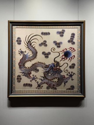 The Republic of China embroidered dragons and played pearls.: Frame mounted silk works, the ground is light. The main body weaves a dragon with distinct scales and claws, with the dragon head facing the fire bead, surrounded by auspicious clouds, and surrounded