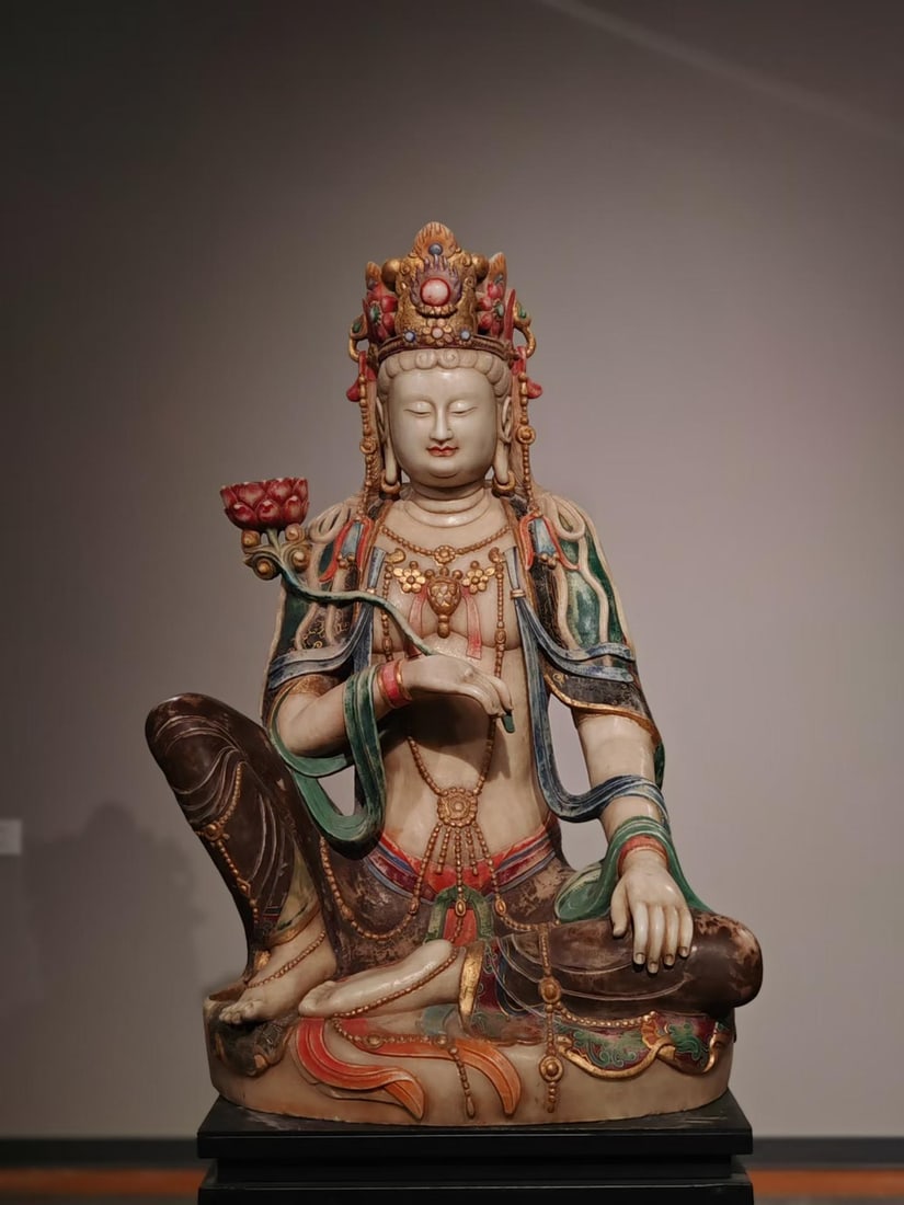 White marble painting is free from Guanyin statue: Stone statues, sitting posture. Wearing a crown, the crown is inlaid with decorations, with a full face and closed eyes. Wearing wreaths all over, wearing silks and holding lotus flowers. The statue