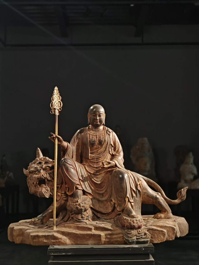 Bluestone painted Tibetan king bodhisattva: Woodcarving statue, the earth treasure king bodhisattva sitting on the beast. Bodhisattva has a round face, a bald head, and a wide-sleeved cassock, with smooth layers of clothes. One hand holds a