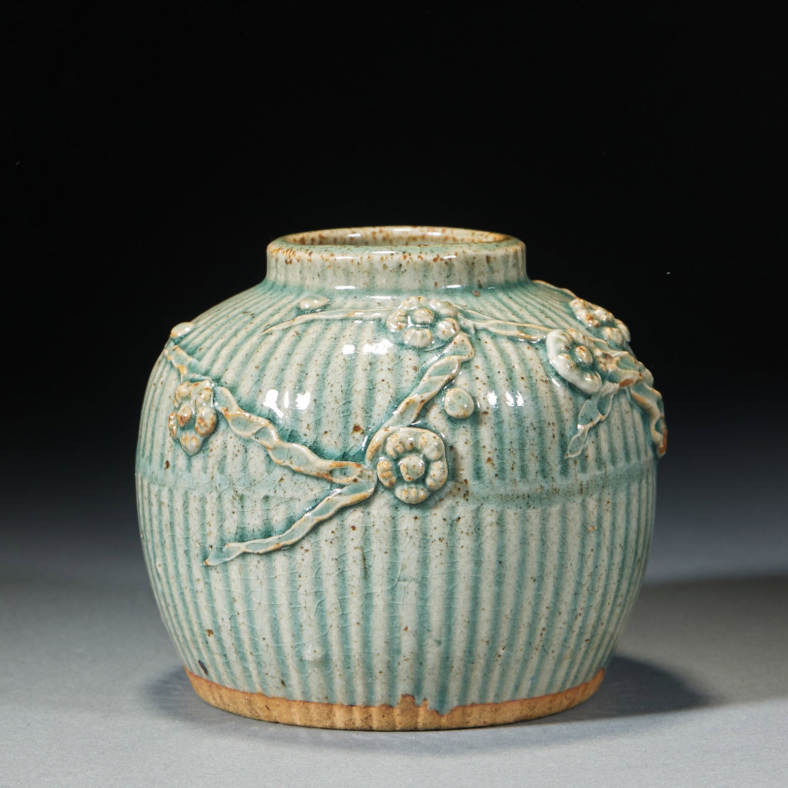 Jun kiln embossed flower jar: Short and straight mouth, rich shoulders, bulging abdomen, abdominal convergence, flat bottom exposed tire. The whole body is vertical with melon ribs, and the green glaze is applied, and the glaze