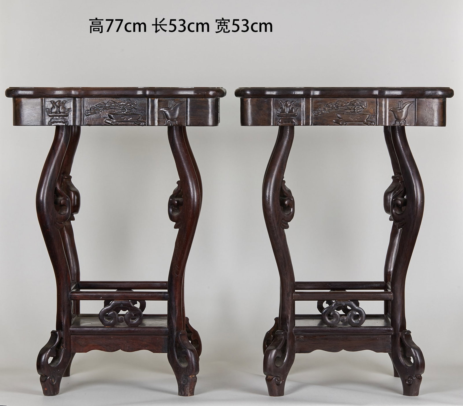 Pair of Wooden Tea Tables: A pair of hardwood flower stands, H 77 cm, L 53 cm, W 53 cm. The top is shaped like a crabapple flower with notched corners; the apron is carved in low relief with bogu (antique-motif) designs of a