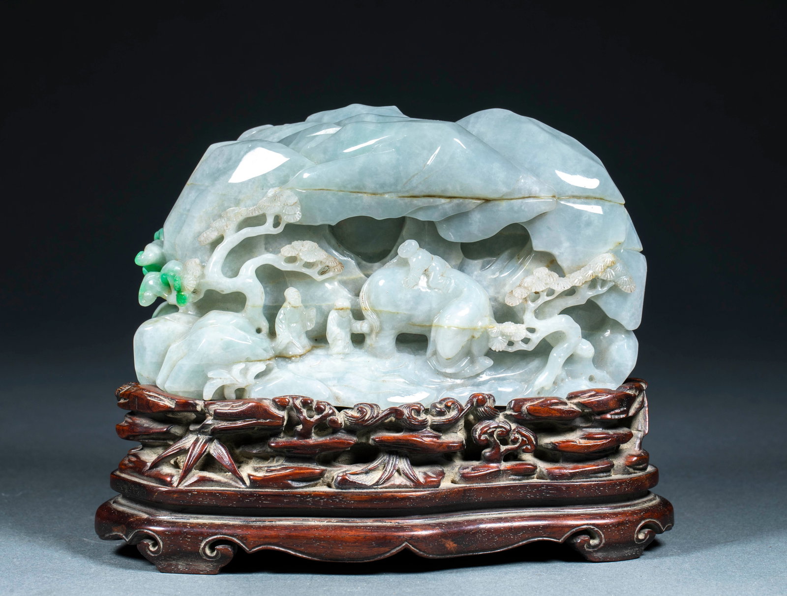 Jadeite Scholar-Washing-Elephant Mountain-Form Ornament: A jadeite boulder carved as a miniature mountain; the jade is ice-green of pale blue-white tone with a patch of deep-green on the left. The surface is undulating; inside the grotto are carved an old