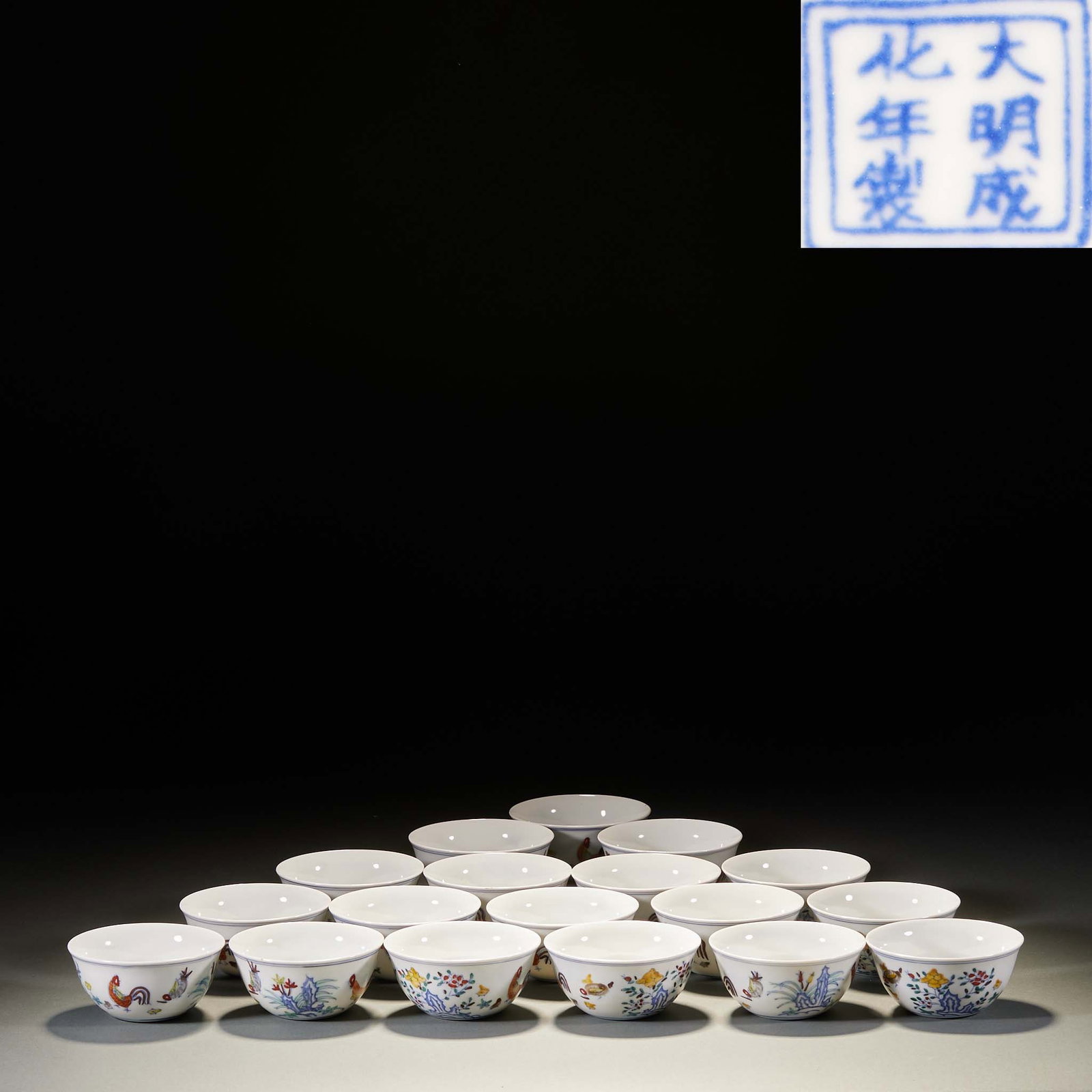 Set of Chenghua Doucai Chicken-Cup, Eighteen Luohans: The base bears the underglaze-blue mark 'Made in the Chenghua reign of the Great Ming'. The cup body is painted in doucai with hens and chicks amid flowers, plants and rocks. The chicken cup is the mo
